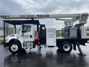 A Best Quality Tree Service bucket truck advertising tree trimming, removal, and stump grinding in Oshkosh, WI.