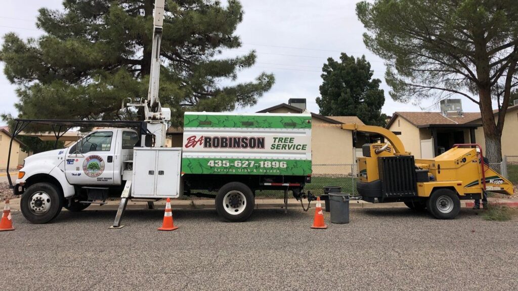 A BA Robinson Tree Service bucket truck and wood chipper parked on a street in Saint George, UT, ready for work.