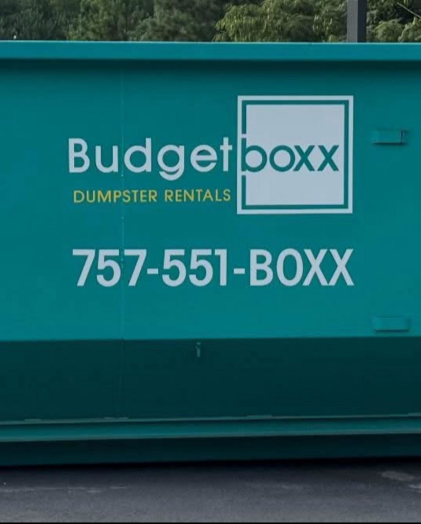 A green Budget Boxx dumpster with the company logo and contact number for junk removal in Suffolk, VA.