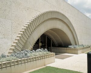 A building entrance featuring a large, decorative cast stone arch, a project by Dallas Cast Stone in Dallas, TX