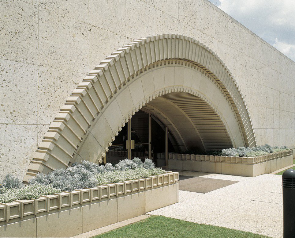 A building entrance featuring a large, decorative cast stone arch, a project by Dallas Cast Stone in Dallas, TX