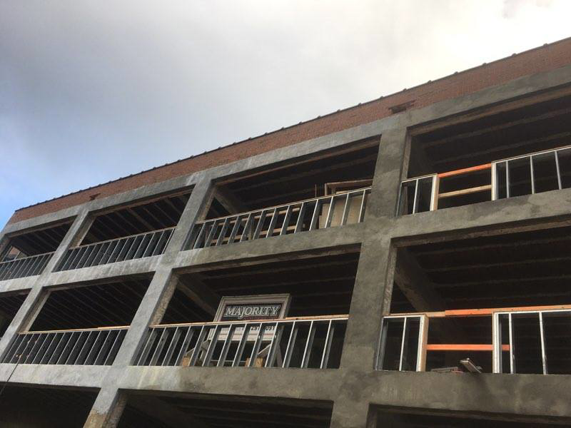 Upper floors of a building under construction, showing concrete framing and metal balcony railings installed by Kemna Restoration & Construction in Indianapolis, IN.