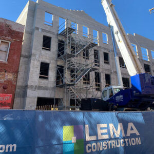 A building under construction with scaffolding and a crane, by LEMA Construction, Inc. in Saint Petersburg, FL.