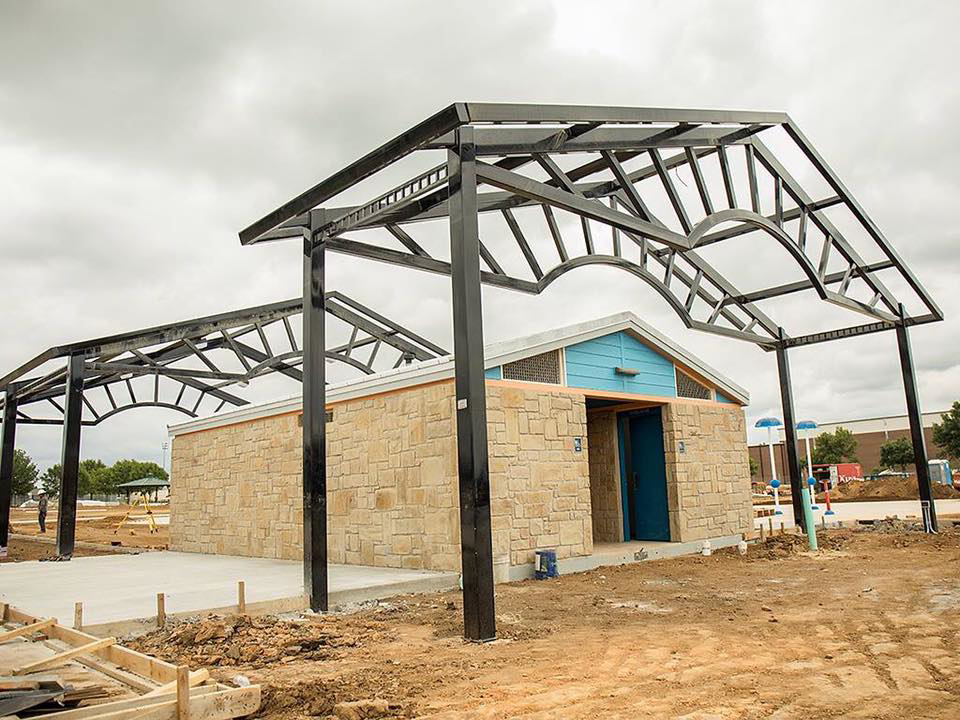 A building under construction with exposed steel framing and stone facade, managed by Northstar Construction, LLC in Fort Worth, TX