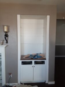 A newly installed built-in bookshelf and cabinet unit, showcasing custom carpentry by Homefix Lawrence in Lawrence, KS.