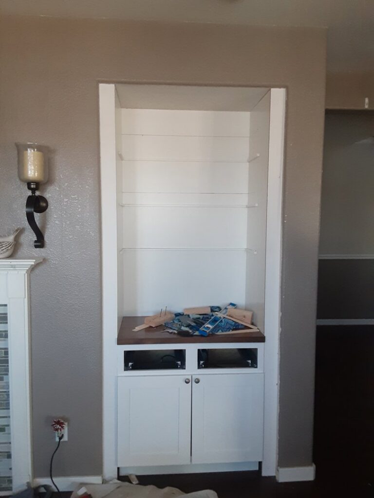 A newly installed built-in bookshelf and cabinet unit, showcasing custom carpentry by Homefix Lawrence in Lawrence, KS.