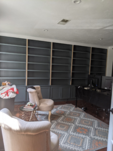 Installation of a large built-in bookshelf unit in a room by Caldwell Construction in Richardson, TX