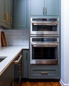 Built-in double ovens and dark green kitchen cabinets, expertly installed by Home Made Easy in Norwalk, CT.