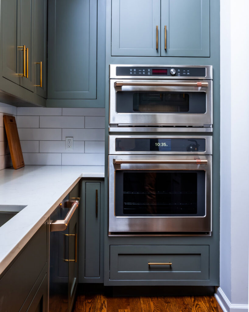 Built-in double ovens and dark green kitchen cabinets, expertly installed by Home Made Easy in Norwalk, CT.