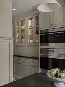 Built-in ovens and custom glass-front cabinets with interior lighting installed by Emergent Construction in Indianapolis, IN.