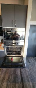 A built-in oven with its door open and a tool inside, indicating repair work by Appliance Handyman of Twin Falls, ID