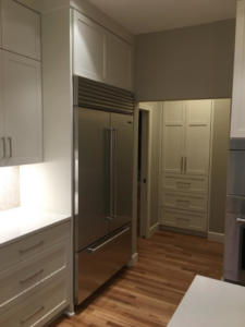 Built-in refrigerator and pantry cabinetry in a modern kitchen by Bailey Contracting, LLC in Lake Oswego, OR.
