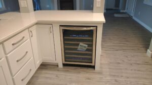 A newly installed built-in wine fridge in a kitchen island by Majestic Homes FW in Fort Wayne, IN.
