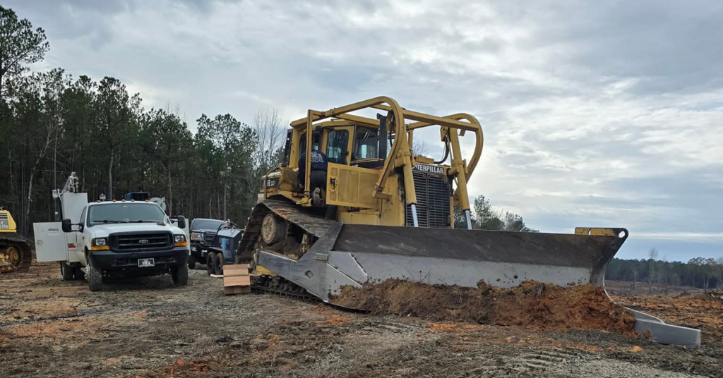 A large bulldozer and a service truck on a job site, showcasing equipment repair by Wise Equipment Services in Rock Hill, SC.