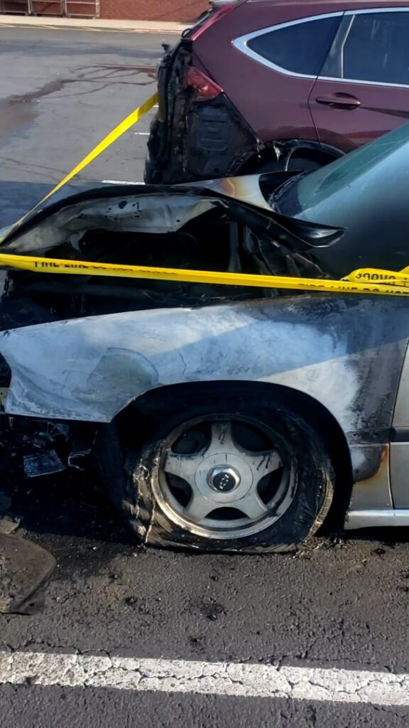 A burnt car with caution tape around it, indicating a junk removal job by Don's Automotive Removal in Thomasville, NC.