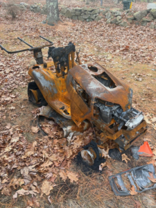 A burnt riding lawnmower ready for removal by Junk Dunkers in Wrentham, MA