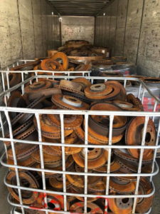 A large cage filled with rusty brake rotors inside a trailer for Metal Recycling Inc in Johnson City, TN