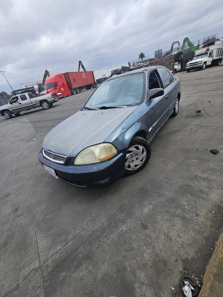 A blue car parked in the lot, likely brought for scrap, at SA Recycling - Long Beach Ave in Los Angeles, CA.