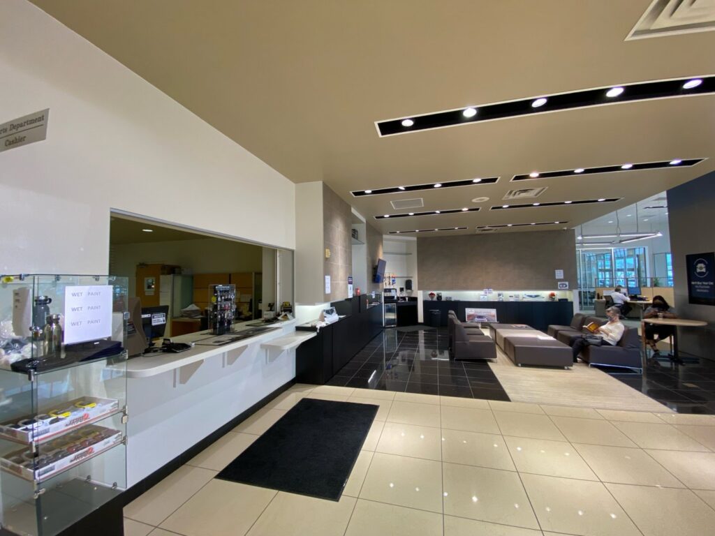 The interior of a car dealership reception and waiting area, a commercial renovation project by Spectrum Paint and Commercial Services, Inc. in Houston, TX.
