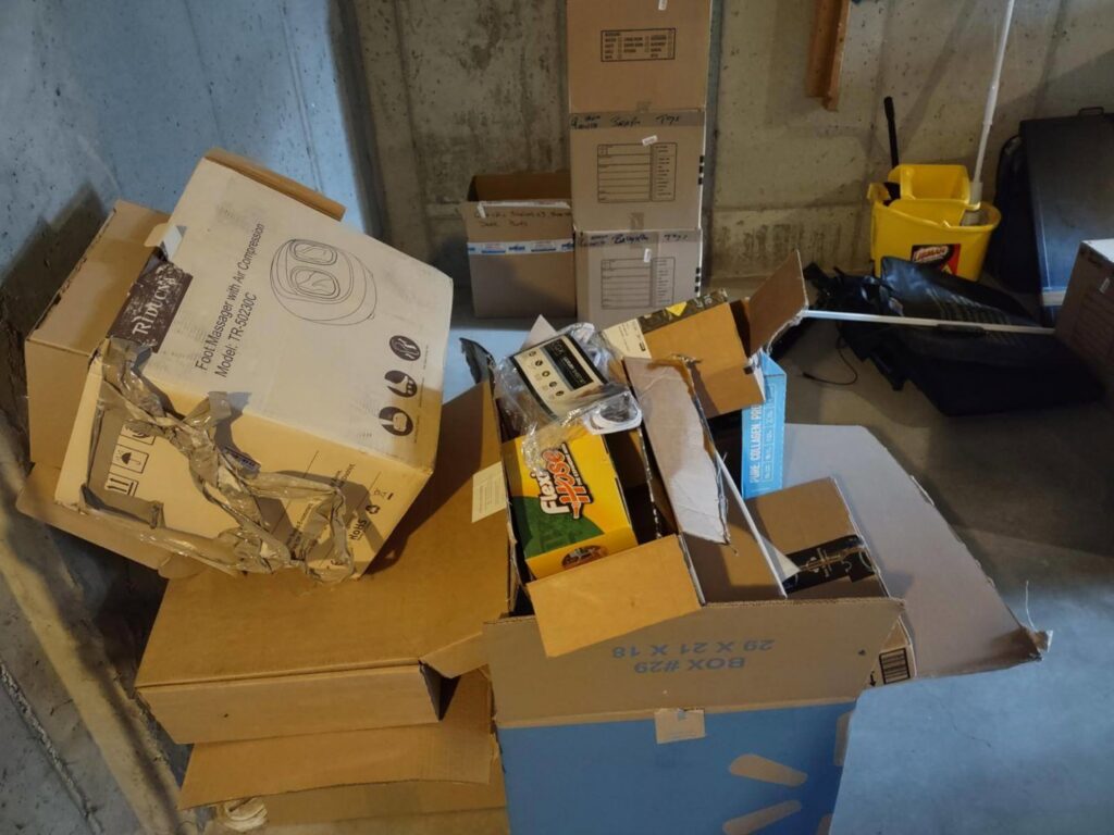 A pile of cardboard boxes and miscellaneous junk in a basement, ready for removal by 1-800-Declutter in Cincinnati, OH.