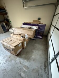 A stack of cardboard boxes and packaging in a garage, ready for junk removal by West LA Hauling in Los Angeles, CA.