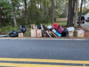 Piles of cardboard boxes and trash bags placed curbside for pickup by Junk Removal JAX in Jacksonville, FL.