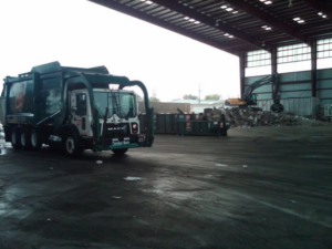 A Carolina Waste junk removal truck parked inside the waste processing facility in Charleston, SC.