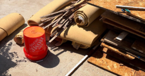 A pile of rolled carpet, wood strips, and construction debris for junk removal by KC Family Haul in Kansas City, KS.