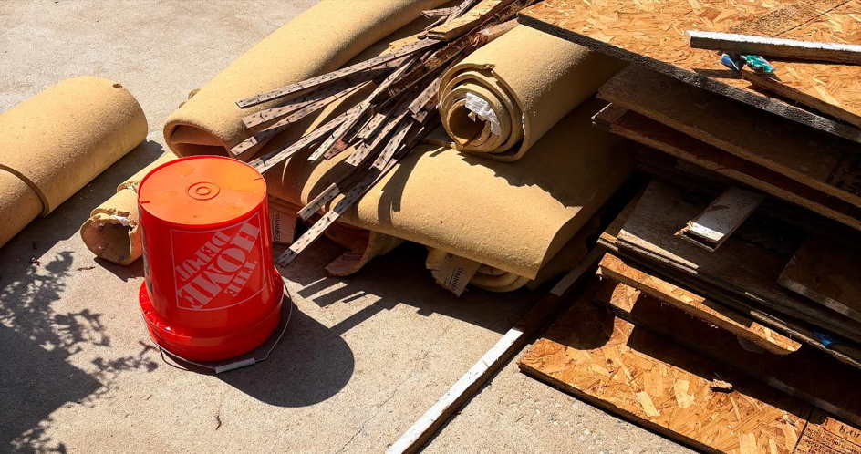 A pile of rolled carpet, wood strips, and construction debris for junk removal by KC Family Haul in Kansas City, KS.