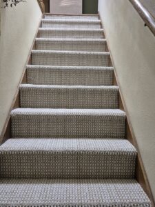 Newly installed patterned carpet on a wooden staircase by Creative Carpets in North Las Vegas, NV.