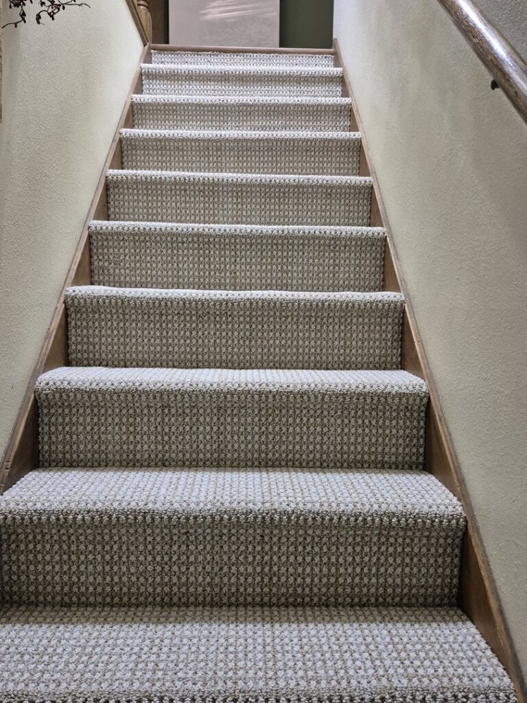 Newly installed patterned carpet on a wooden staircase by Creative Carpets in North Las Vegas, NV.
