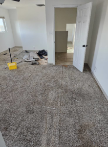 Carpet removal and floor preparation in a room, showing debris and subfloor by AV Handyman Services in Rio Rancho, NM.