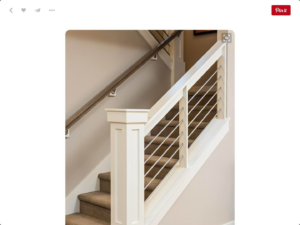 A carpeted staircase featuring white newel posts and modern cable railings by Werling Construction in Newport News, VA