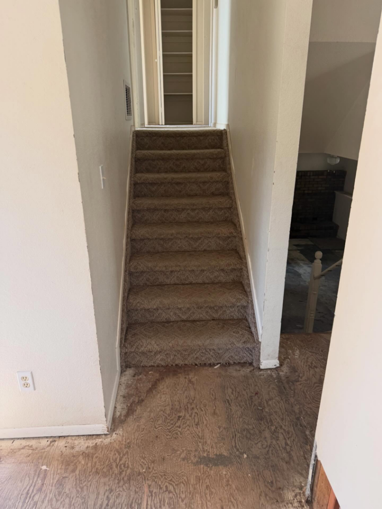 A carpeted staircase with exposed subfloor at the bottom, indicating flooring or renovation work by Radiant Homes LLC in Denver, CO.