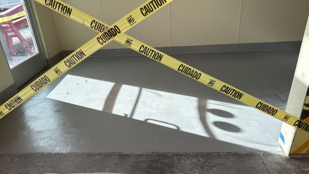 A freshly treated floor section marked with caution tape, indicating recent work by ACT Restoration in Andover, MN.