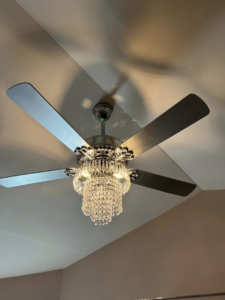 A modern ceiling fan with a decorative crystal light fixture installed by GOAT Tv Mounting & Home Improvement L.L.C in Toledo, OH.