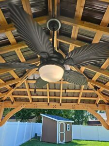 A newly installed ceiling fan with lights under a wooden gazebo roof by MorLite Electric in Newport News, VA.
