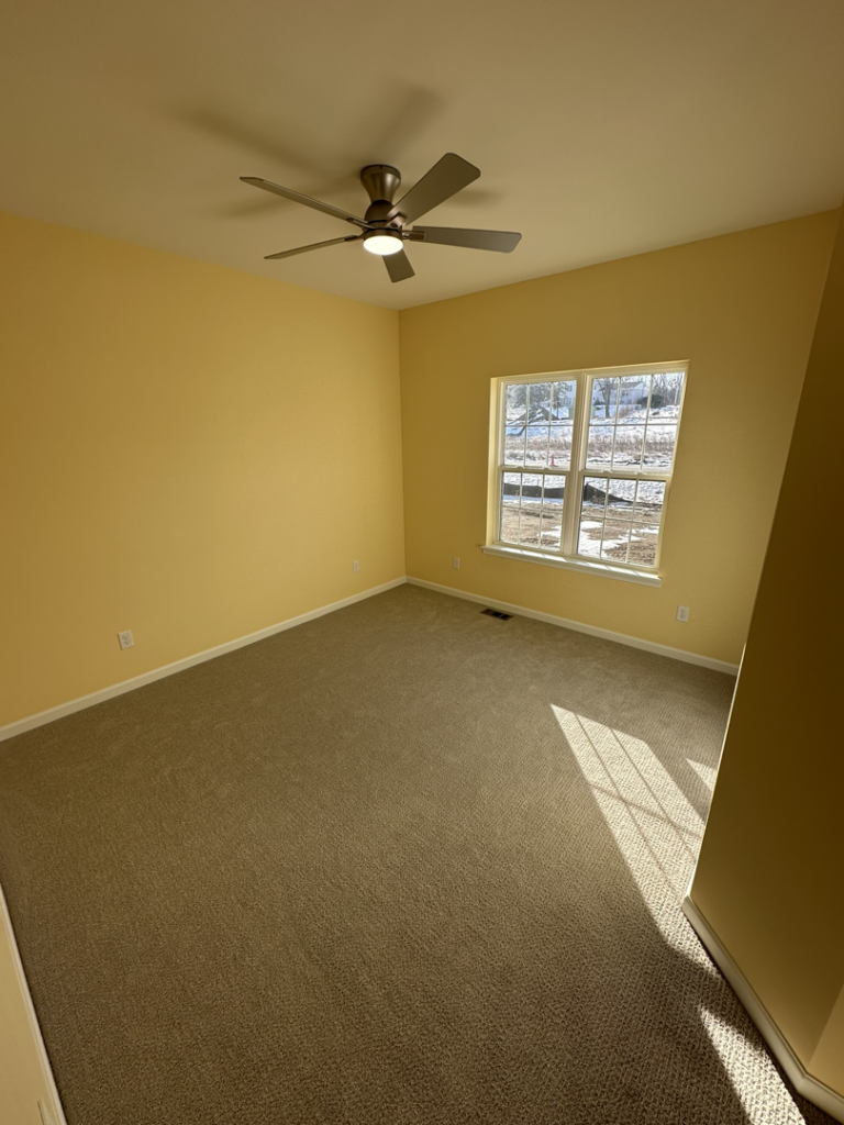 A newly installed ceiling fan in a yellow room by Harpe Development LLC in Kenosha, WI.