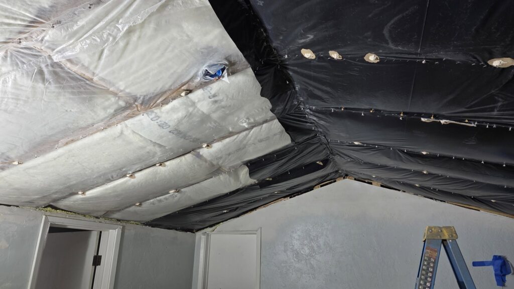 Ceiling insulation and black vapor barrier being installed, a service by Infinity Handyman in Anchorage, AK