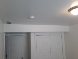 A finished ceiling with a smoke detector, air vent, and light fixture, installed by Eagle Rock Handyman Services in Caldwell, ID.