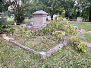 A cemetery plot covered with fallen tree branches and debris, ready for cleanup by Stone Cold Restorations in Durham, NC.
