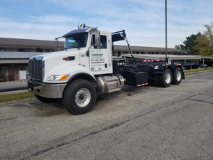 A white Century Waste Management roll-off truck parked in Sterling Heights, MI, ready for junk removal services.
