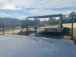 A newly installed chain-link fence and gate leading to a picnic area by Legacy Fence, LLC in Aiken, SC.