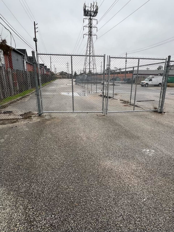 A newly installed chain-link fence and gate at a job site by All Aboard Contractors in Houston, TX.