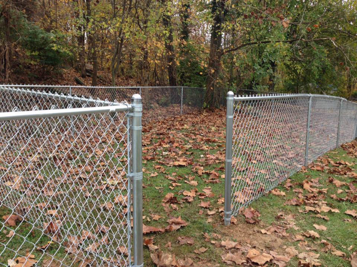 A newly installed chain-link fence in a residential backyard by Fence & More in Elizabethtown, KY