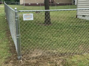 A chain link fence installed with a company sign by Premier Fence Company in Glen Allen, VA.