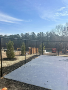 A new chain-link fence surrounding a property with fresh landscaping by Legacy Fence, LLC in Aiken, SC.