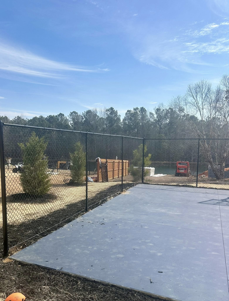 A new chain-link fence surrounding a property with fresh landscaping by Legacy Fence, LLC in Aiken, SC.