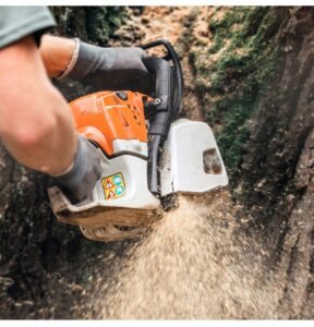 Close-up of a chainsaw cutting into a tree trunk, creating sawdust, by Arborscape Tree Care in Ankeny, IA.