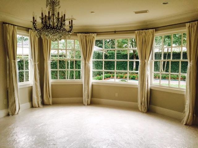 A large crystal chandelier installed in a room with protective floor covering, showcasing handyman services by Northshore Custom Homes in Covington, LA.